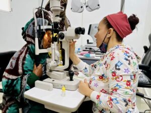 La Dra. Elisabeth Velázquez revisando la vista a una paciente La Dra. Elisabeth Velázquez revisando la vista a una paciente
